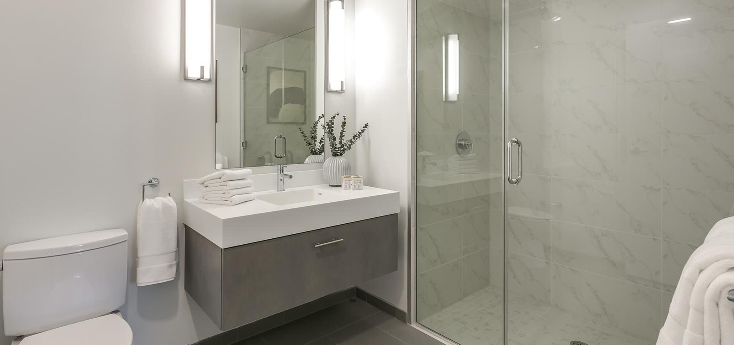 The bathrooms in the monarch are adorned with vanities, tiled flooring, porcelain toilets, and polished chrome plumbing fixtures.