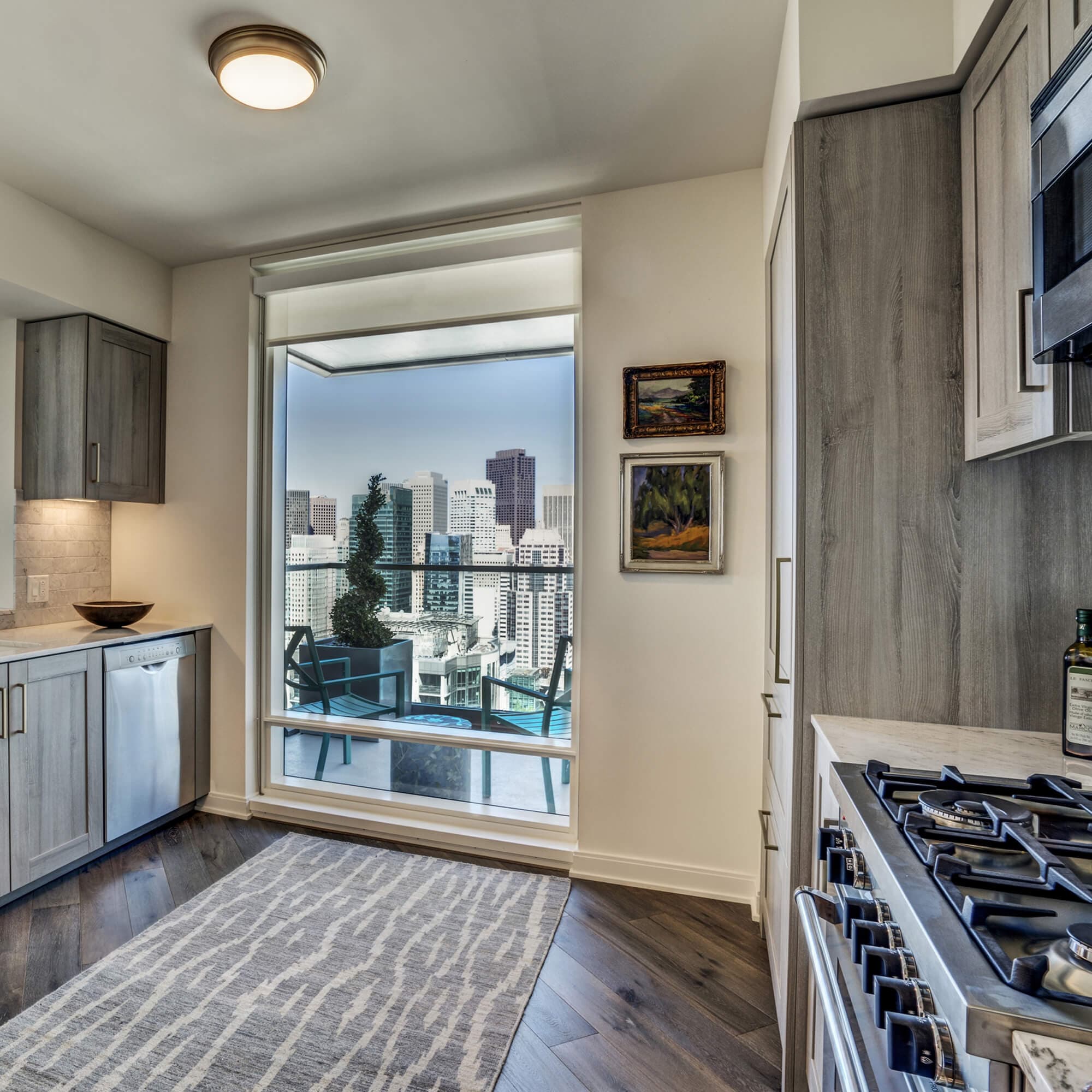 Planked Siberian oak flooring and white marble countertops direct the eye towards large windows with bay or city views (depending on the unit) in a kitchen that is perfect for cooking for a few or many people. 