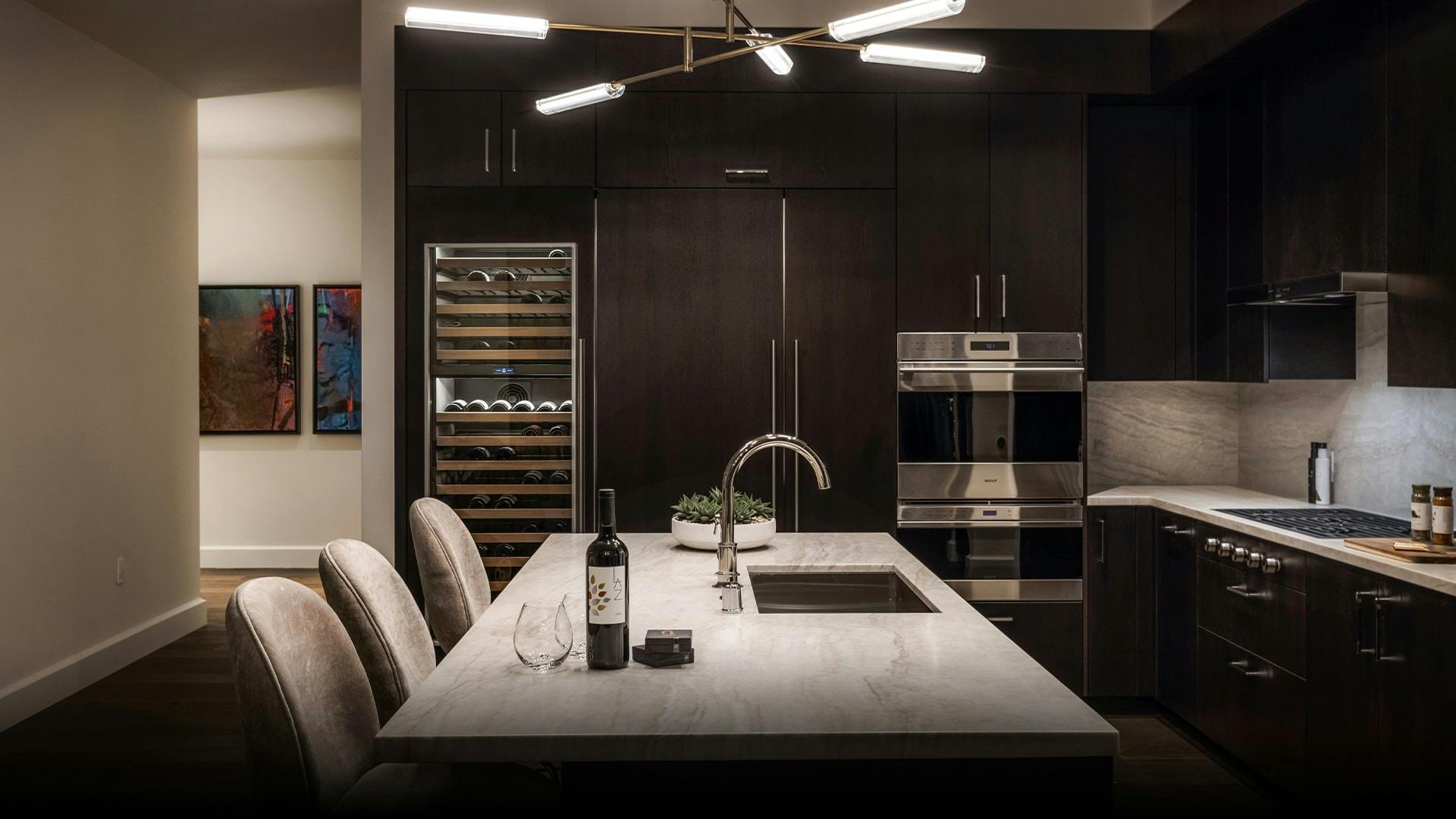 The Aronson residences of the Four Seasons provide a gourmet kitchen experience that is complete with Madreperola quartzite countertops and custom-stained ebony cabinets with white interiors. 