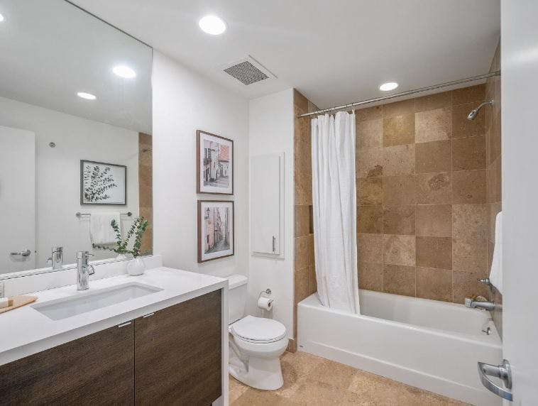 Bathrooms are adorned with shower-over-tub set ups in guest bathrooms and standing showers in the master. They display a tiled design with custom cabinetry. 